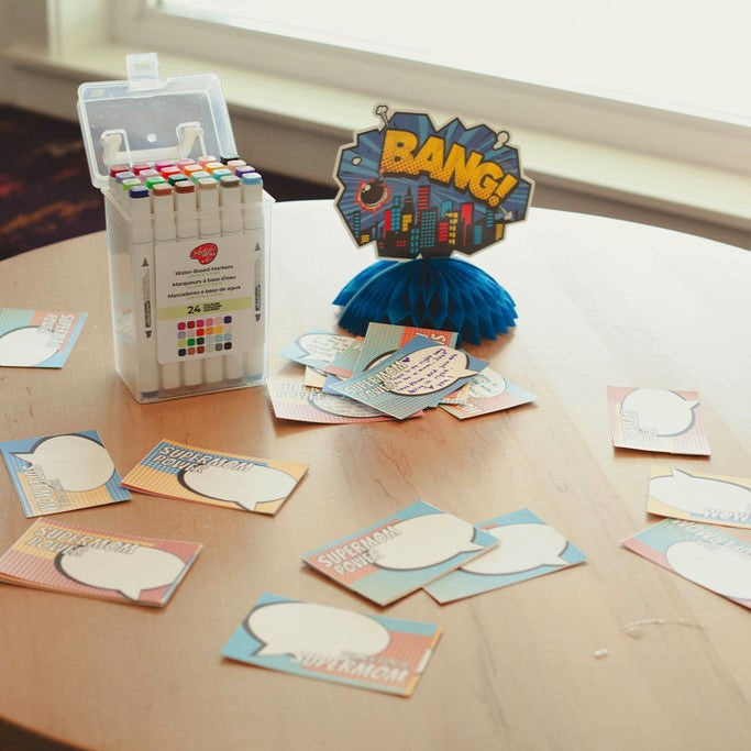 Colorful markers in a case with speech bubble cards on a table.